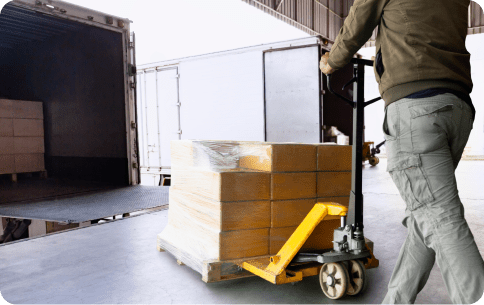 man on a loading dock pushing carts into a truck